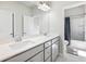 Bright bathroom featuring double vanity sinks, white countertops, and a shower-tub combo with a shower curtain at 6145 Stargazer Way, Cumming, GA 30028