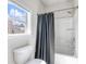 Modern bathroom featuring a shower-tub combo with a gray shower curtain and a window at 6145 Stargazer Way, Cumming, GA 30028