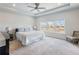 Spacious main bedroom with tray ceilings, a ceiling fan, and a large window overlooking the pond at 6145 Stargazer Way, Cumming, GA 30028