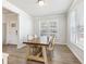 Dining room with natural light features a large wooden table, chairs, and views into adjacent rooms at 6145 Stargazer Way, Cumming, GA 30028