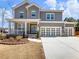 Charming gray two-story home boasts a welcoming front porch and a spacious three-car garage at 6145 Stargazer Way, Cumming, GA 30028