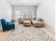 Well-lit sitting room showcases an inviting blue armchair and a comfortable sectional sofa at 6145 Stargazer Way, Cumming, GA 30028