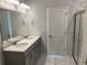 Bathroom featuring double sink vanity, quartz countertop, and marble-look tile floor, with a glass shower door at 670 Pineberry Dr, Grayson, GA 30017