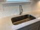 Close-up of a kitchen sink with quartz countertops and a herringbone backsplash at 670 Pineberry Dr, Grayson, GA 30017