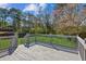 Wooden back deck and railing overlooking a large green lawn and fenced perimeter at 1604 Quail Sw Run, Conyers, GA 30094