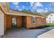 Brick home featuring a cozy covered entryway, gray shutters and landscaped mulched garden bed at 1604 Quail Sw Run, Conyers, GA 30094