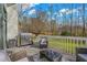 Outdoor patio with seating, grill, and railing overlooking the landscaped yard and wooded area at 3775 Lake Seminole Dr, Buford, GA 30519