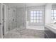 Modern bathroom features a glass shower and a luxurious soaking tub surrounded by elegant marble-like tiling at 3775 Lake Seminole Dr, Buford, GA 30519