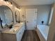 Bathroom featuring double vanity, tub, and granite counters at 488 West Ave, Bowdon, GA 30108