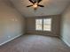 Neutral bedroom with carpet and a ceiling fan, with windows for natural light at 488 West Ave, Bowdon, GA 30108