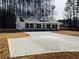 View of a newly poured concrete driveway leading up to a home with white siding and dark shutters at 488 West Ave, Bowdon, GA 30108