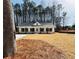 Exterior of house with white siding, stone accents, dark shutters and a long driveway at 488 West Ave, Bowdon, GA 30108