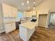 Contemporary kitchen with granite countertops, white cabinets, and hardwood floors at 488 West Ave, Bowdon, GA 30108