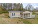 Tan manufactured home with a screened porch and a small deck on a grassy lawn at 718 Old Tennessee Ne Hwy, White, GA 30184