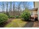 Grassy backyard with a lush garden and wooden steps to the house at 2883 Observation Nw Pt, Marietta, GA 30064