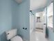 Light blue bathroom with white tile floors, toilet, and a view into the vanity area at 2883 Observation Nw Pt, Marietta, GA 30064