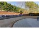 Spacious backyard featuring a stone retaining wall, potted plants, and lush trees at 4030 Crescent Walk Ne Ln, Suwanee, GA 30024
