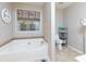 Relaxing bathroom featuring a soaking tub, mosaic tile accents, and stylish decor elements at 4030 Crescent Walk Ne Ln, Suwanee, GA 30024
