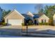 Charming brick home featuring a well-manicured lawn, mature landscaping, and attached two-car garage at 4030 Crescent Walk Ne Ln, Suwanee, GA 30024