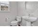 Powder room featuring a pedestal sink, toilet, and a window for natural light at 4874 Seldon Se Way, Smyrna, GA 30080