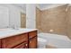Cozy bathroom featuring a bathtub with beige tile surround and a wooden vanity at 4874 Seldon Se Way, Smyrna, GA 30080