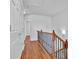 Hallway with wood floors, storage closet, and decorative metal staircase railing at 4874 Seldon Se Way, Smyrna, GA 30080