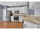 Kitchen features stainless steel appliances, white cabinets, granite countertops and hardwood floors at 4874 Seldon Se Way, Smyrna, GA 30080