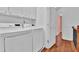 Upstairs laundry room with white washer and dryer, and upper cabinets at 4874 Seldon Se Way, Smyrna, GA 30080
