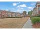 View of the street with well-maintained townhomes, landscaping, and open green space at 4874 Seldon Se Way, Smyrna, GA 30080