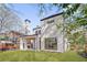 Rear exterior of modern home with tall chimney, covered patio, and spacious lawn for outdoor enjoyment at 555 Orme Ne Cir, Atlanta, GA 30306