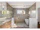 Elegant bathroom featuring a soaking tub, glass shower enclosure, double vanity with marble countertop, and marble floors at 555 Orme Ne Cir, Atlanta, GA 30306