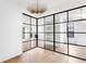 Bright living room featuring floor-to-ceiling glass wall with black trim, hardwood floors, and modern light fixture at 555 Orme Ne Cir, Atlanta, GA 30306
