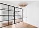Bright living room featuring floor-to-ceiling glass wall with black trim, hardwood floors, and modern light fixture at 555 Orme Ne Cir, Atlanta, GA 30306