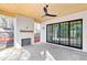 Outdoor patio with stone floors, wood ceiling, ceiling fan, black trimmed sliding glass doors, and herringbone fireplace at 555 Orme Ne Cir, Atlanta, GA 30306