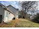 Side exterior featuring neutral siding, access door and view of a grassy yard at 738 Windsor Cir, Lawrenceville, GA 30046
