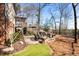 Beautiful backyard with a stone fire pit, paver patio, elevated deck, and manicured landscaping at 8850 Appling Rdg, Cumming, GA 30041