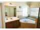 Bright bathroom with a soaking tub, neutral tile, and natural light at 1092 Park Hollow Ln, Lawrenceville, GA 30043