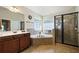 Bathroom featuring a soaking tub, glass enclosed shower and double vanity with granite countertop at 1092 Park Hollow Ln, Lawrenceville, GA 30043