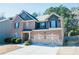 Traditional two-story brick home with an attached two-car garage and mature landscaping surrounding the property at 1092 Park Hollow Ln, Lawrenceville, GA 30043