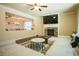 Comfortable living room with a cozy fireplace, a modern ceiling fan, and seamless view of the dining room at 1092 Park Hollow Ln, Lawrenceville, GA 30043