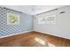 Bedroom with hardwood floors, bright natural light, and decorative blue wallpaper accent wall at 1415 Dalewood Ne Dr, Atlanta, GA 30329