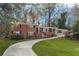 Charming brick home with a well-manicured lawn and a long driveway, surrounded by mature trees at 1415 Dalewood Ne Dr, Atlanta, GA 30329