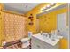 Bright, yellow bathroom features a shower with curtain, a sink with mirror, and bee wall decorations at 5545 Circlestone Ln, Stone Mountain, GA 30083