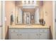 Bathroom vanity with granite countertop and white cabinets, featuring a large mirror reflecting the doorway at 159 Tara Blvd, Loganville, GA 30052