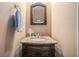 Bathroom vanity with dark wood cabinet and granite countertop, featuring a decorative mirror at 159 Tara Blvd, Loganville, GA 30052