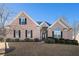 Charming single-Gathering brick home with mature landscaping and black shutters under a clear blue sky at 159 Tara Blvd, Loganville, GA 30052