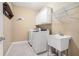 Functional laundry room featuring washer, dryer, utility sink, cabinets, and shelving at 159 Tara Blvd, Loganville, GA 30052