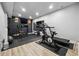 This is a large finished basement gym with mirrored walls, a TV and exercise equipment at 4440 Croftshire Pl, Cumming, GA 30040