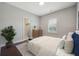 Comfortable bedroom features a neutral color palette, wood floors, and an arched window with modern blinds at 4440 Croftshire Pl, Cumming, GA 30040