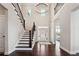 Grand foyer features a soaring ceiling, a staircase with dark wood accents, and abundant natural light at 4440 Croftshire Pl, Cumming, GA 30040